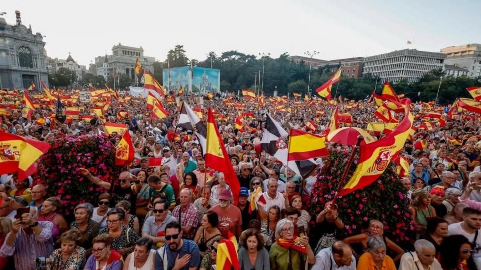 Una multitud ondea banderas de España en la plaza de Cibeles de Madrid durante una manifestacion